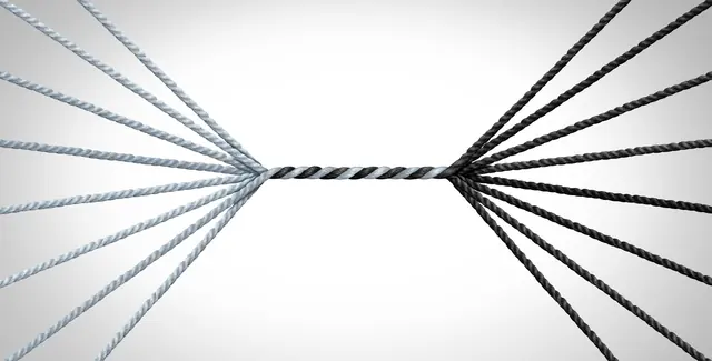 Two bundles of rope pulled taut from opposite sides, joined at a single thin strand in the middle
